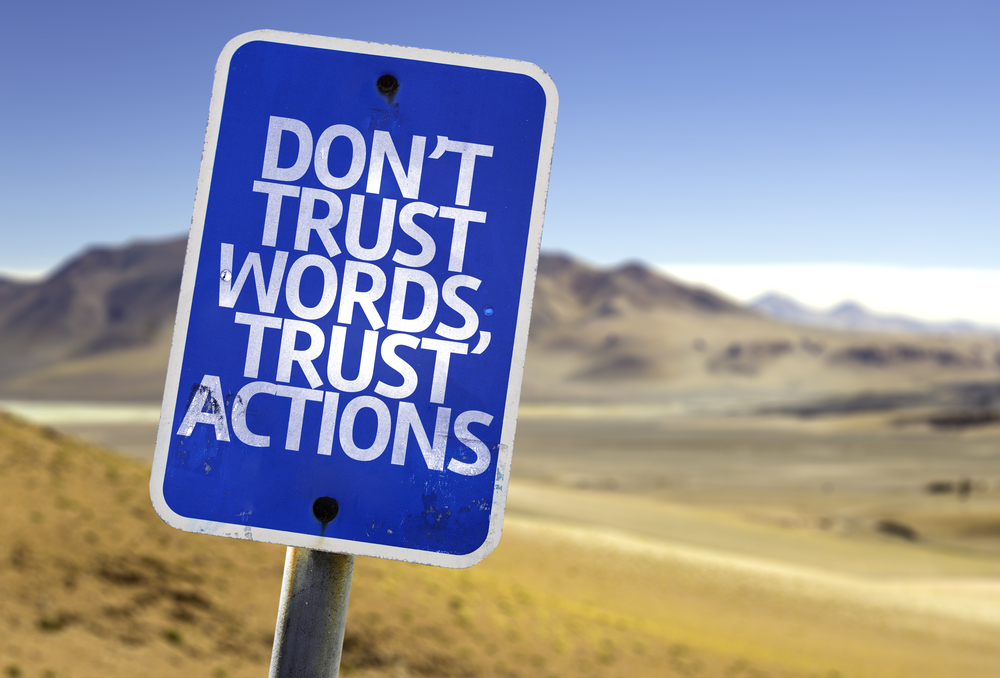 Dont Trust Words, Trust Actions sign with a desert background